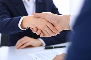 a banker shaking hands with a businessman who is looking to open up a Fairfax, VA CD account so that he can begin earning more money on interest