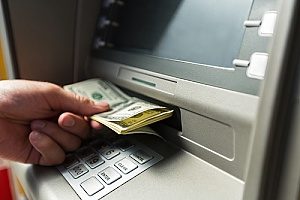 a man using an ATM which is part of his interest checking account plan