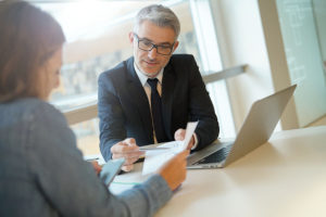 a woman in a banker's office signing for a business line of credit