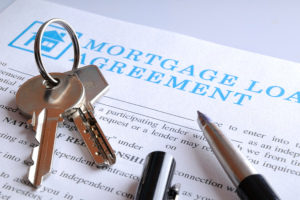 keys and a pen on top of a mortgage loan agreement for a business mortgage loan