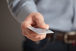 a business man holding a debit card from his savings account