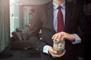business owner holding money in a jar