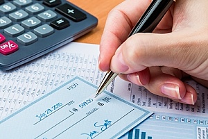 a business owner writing a check to a vendor who has positive pay